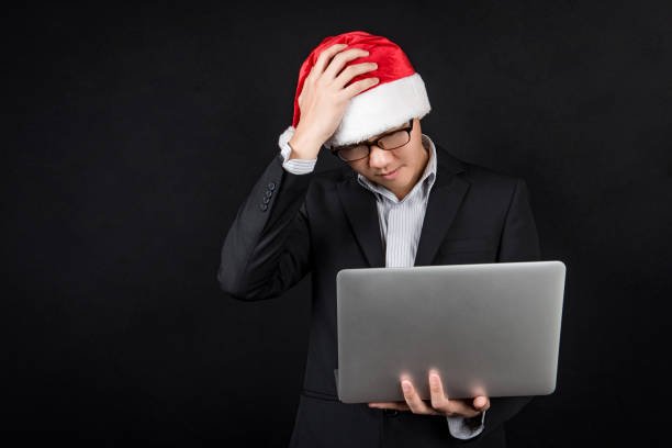 istock Young Asian businessman with santa hat using laptop 886374570