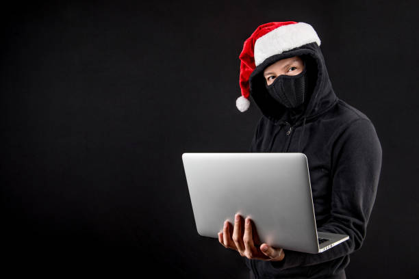 istock mysterious male santa hacker holding laptop computer 886378768