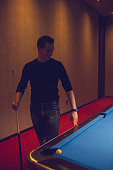istock Young man playing pool 886381362