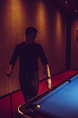 istock Young serious man thinking of his next billiard move. 886381544
