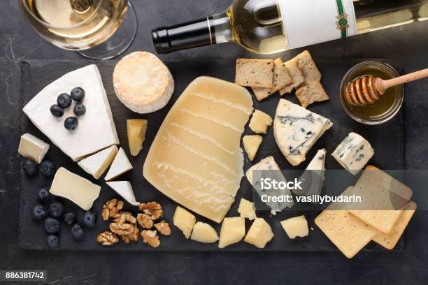 Photo libre de droit de Dégustation De Plat De Fromage Sur Une Plaque En Pierre Sombre Nourriture Pour Vin Et Rendezvous Romantique Charcuterie Fromage Sur Un Fond De Béton Noir Vue De Dessus banque d'images et plus d'images libres de droit de Fromage