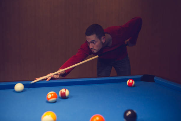istock Young male playing snooker. 886387272