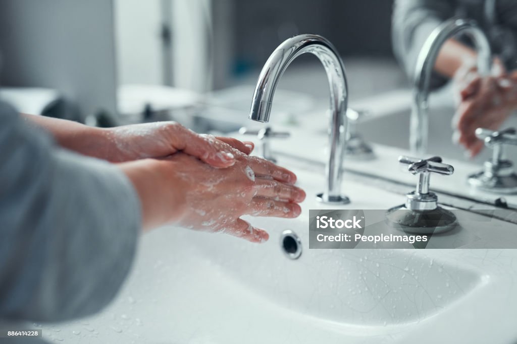 It's vital to practice good personal hygiene Closeup shot of an unrecognizable woman washing her hands in the bathroom at home Washing Hands Stock Photo
