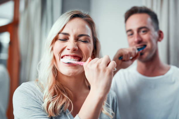 Gotta keep them whites extra bright! Portrait of a young couple brushing their teeth together in the bathroom at home toothbrush stock pictures, royalty-free photos & images