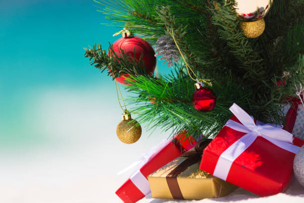 istock Christmas presents and decorated tree against ocean background 886416698