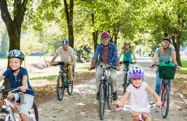 istock Family Cycling Together Through Park 886432100