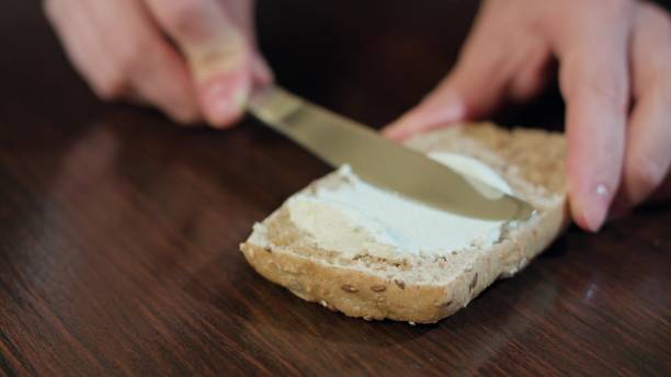 istock Female Hands Spreading Butter on Bread 886432462