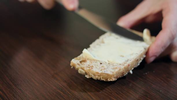 istock Female Hands Spreading Butter on Bread 886432526