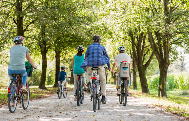 istock Family Cycling Together Through Park 886439426