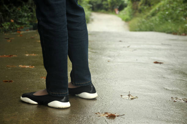istock Person standing on sidewalk in a rainy day; autumn 886450422