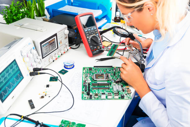 ingegnere elettronico donna che controlla circuito stampato in laboratorio - operaio di produzione foto e immagini stock