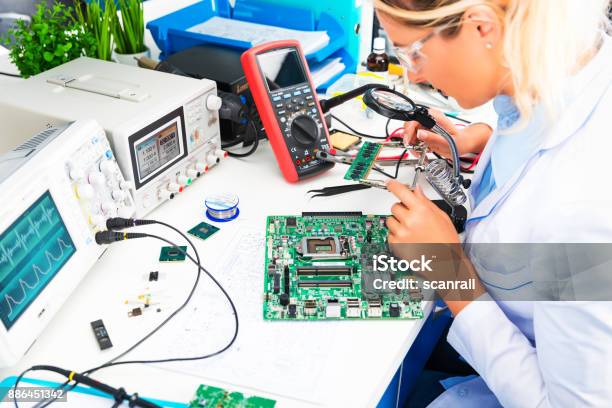 Ingegnere Elettronico Donna Che Controlla Circuito Stampato In Laboratorio - Fotografie stock e altre immagini di Industria elettronica