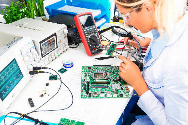 女性電子技術者は研究室で基板をチェック - circuit board electrical equipment engineering technology ストックフォトと画像