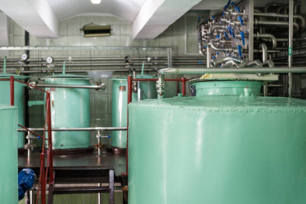istock Large riveted metallic cisterns of light green color 886474768