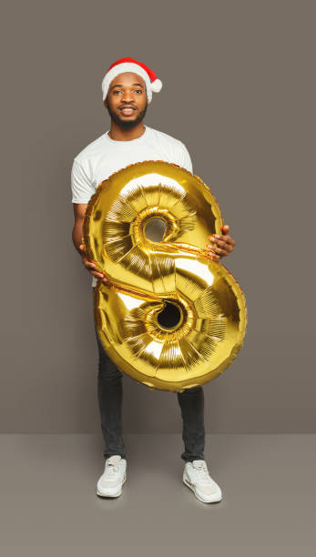 istock Black man with number 8 balloon portrait 886476804