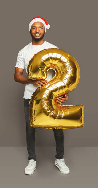 istock Black man with number 2 balloon portrait 886478904