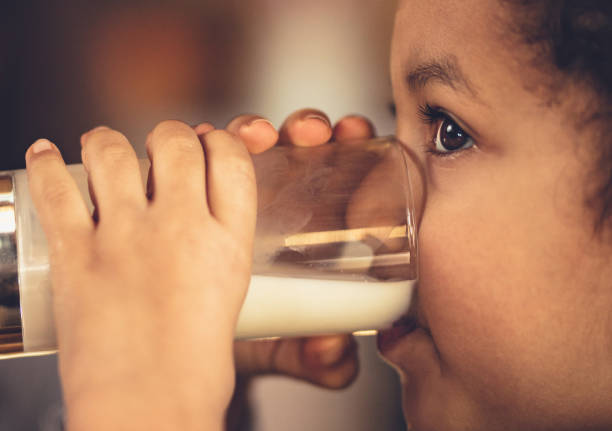 istock Close up of small black boy drinking fresh milk. 886482542
