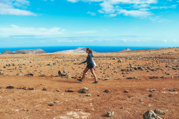 istock Young woman hiking with panoramic view on volcano 886482762