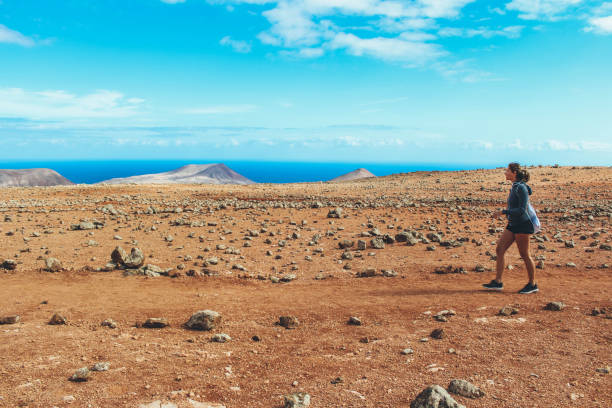 istock Young woman hiking with panoramic view on volcano 886482938