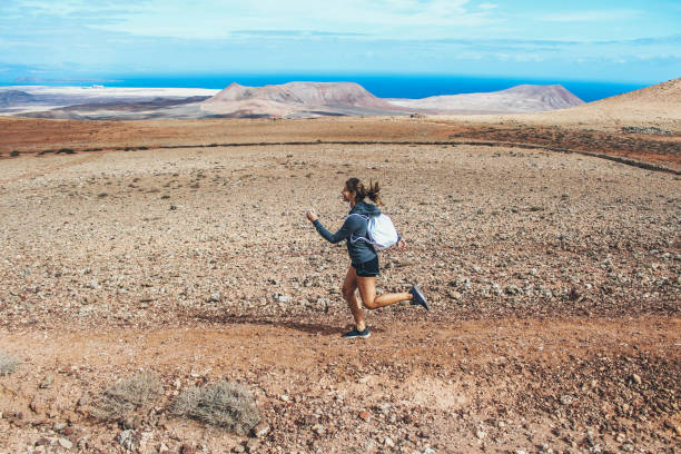 istock Young woman running on volcano 886483016
