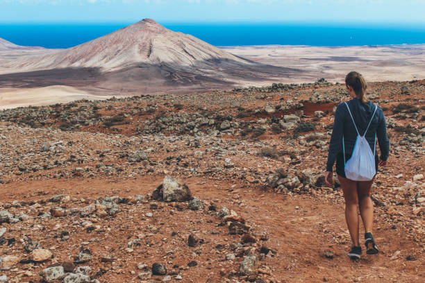istock Young woman hiking with panoramic view on volcano 886485182
