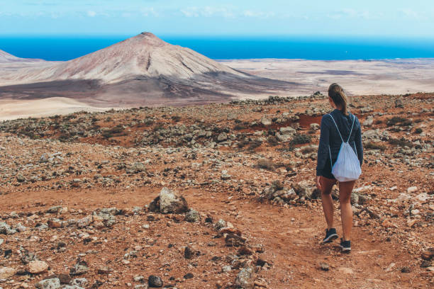 istock Young woman hiking with panoramic view on volcano 886487362
