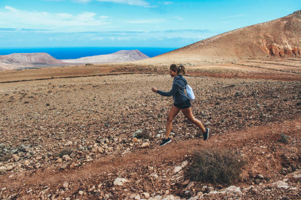 istock Young woman running on volcano 886487452