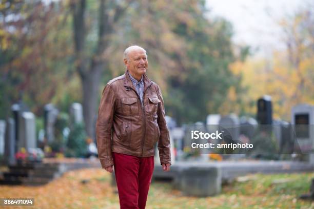 Seniors 73 Years Active Modern Senior Man Taking A Walk Through Cemetery In Autumn Stock Photo - Download Image Now