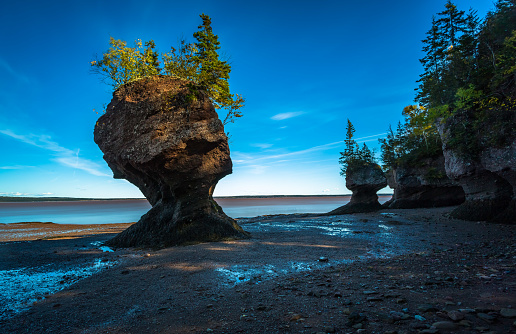At Hopewell Rocks one can experience the world's highest tides and take a walk on the ocean floor. The tides rise up to 4 metres (13 vertical feet) per hour and can reach a height of up to 14 metres (46 feet) and are located in New Brunswick, New England, Canada.