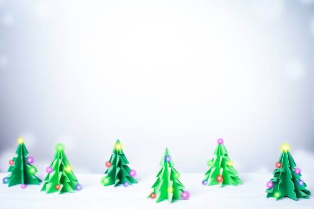 istock Paper cut christmas tree with light in snowy winter background 886494778