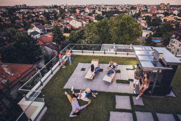 sopra la vista di amici felici che si rilassano su un balcone dell'attico. - common area foto e immagini stock