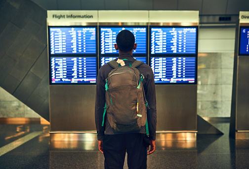 Shot of a man checking the flight times in an airport