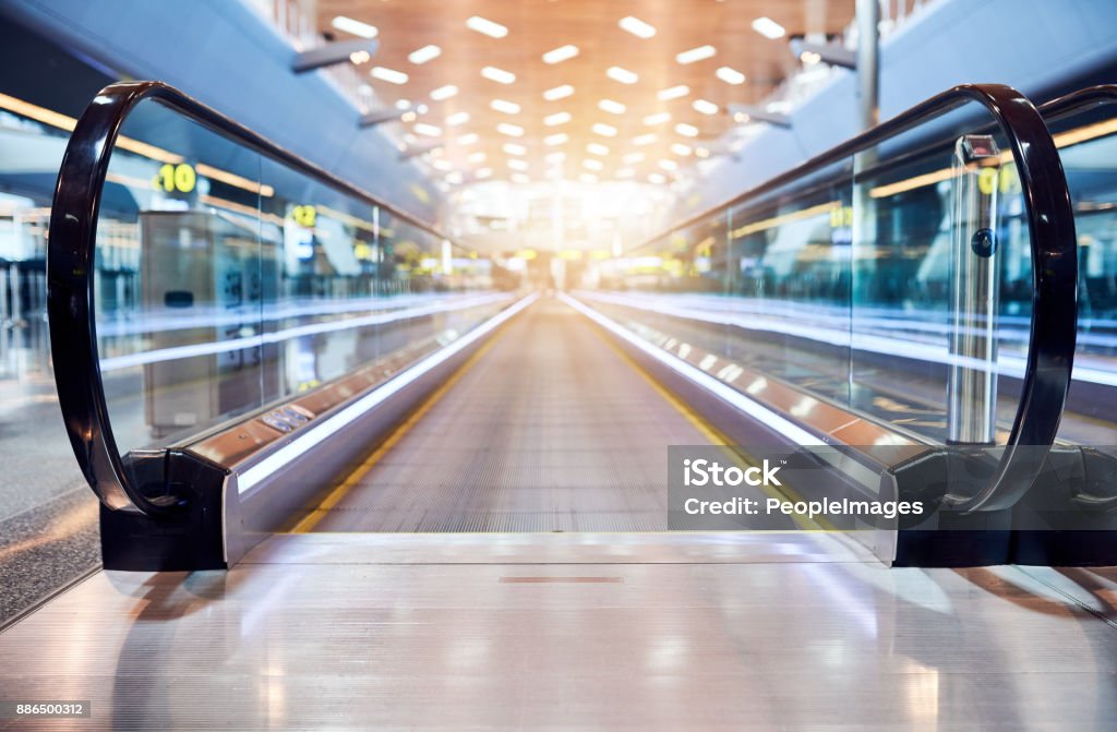 The way towards the plane Shot of a moving walkway in the airport Airport Stock Photo