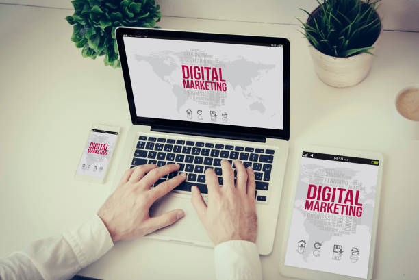 istock hands writing on a laptop with tablet and phone digital marketing 886503392