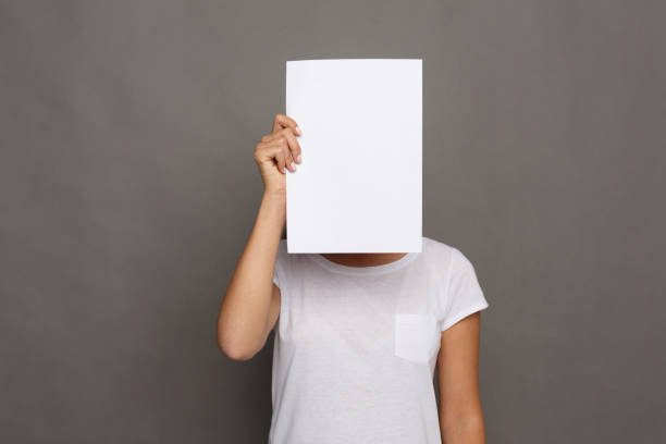 istock Young woman with blank white paper at face 886503870