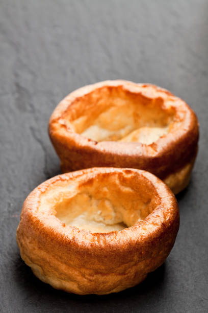 pudines de yorkshire aislados sobre fondo negro piedra - yorkshire pudding fotografías e imágenes de stock