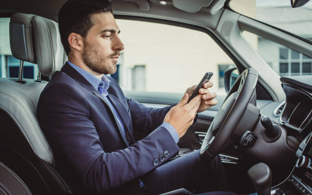 istock Businessman in the Car Using Smart Phone 886521010