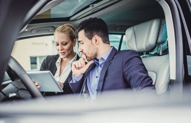 istock Business Couple in the Car, Using Portable Devices 886521114