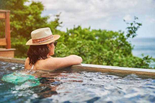istock Young woman in bikini staying in pool 886532962