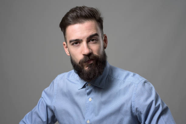 istock Skeptical suspicious young bearded stylish businessman looking at camera with one eyebrow raised 886533594