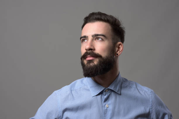 Confident young handsome stylish business man looking up at copyspace