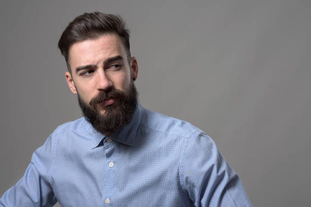 istock Young handsome bearded stylish confident hipster looking back over the shoulder at copyspace 886538636
