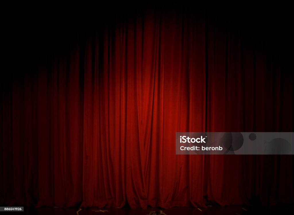 Red Curtain in the theater The Red Curtain in the theater is illuminated with a single reflector Curtain Stock Photo