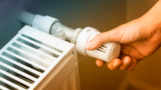 istock Hand Adjusting The Temperature Of A Heating Radiator 886556982