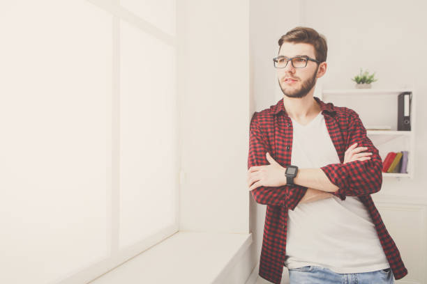 istock Confident young businessman at office near window 886564498