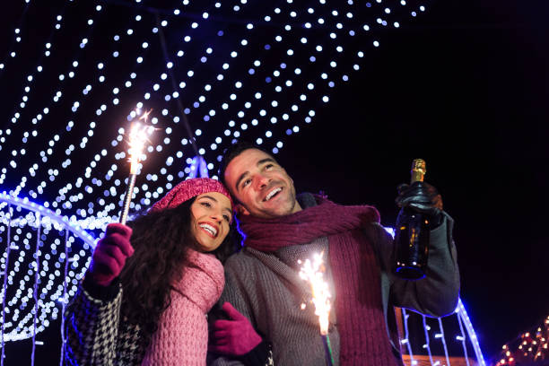 istock Young couple having fun with sparkling candles at night 886582628