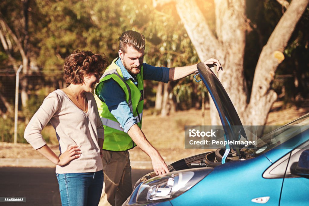 This is the problem right here Shot of a young woman receiving roadside assistance from a young man after breaking down Car Stock Photo