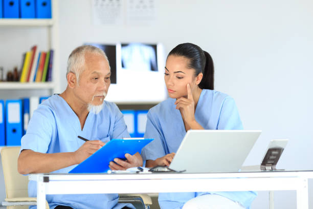 istock Medical student and senior doctor filling documents 886593740