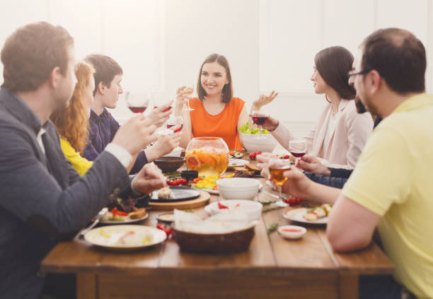 istock Group of happy people at festive table dinner party 886595030