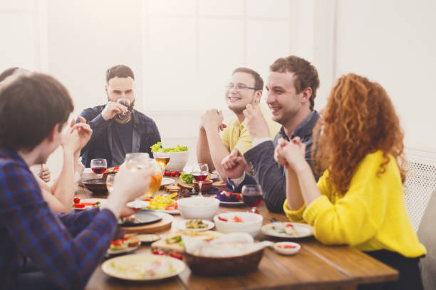 istock Group of happy people at festive table dinner party 886595128